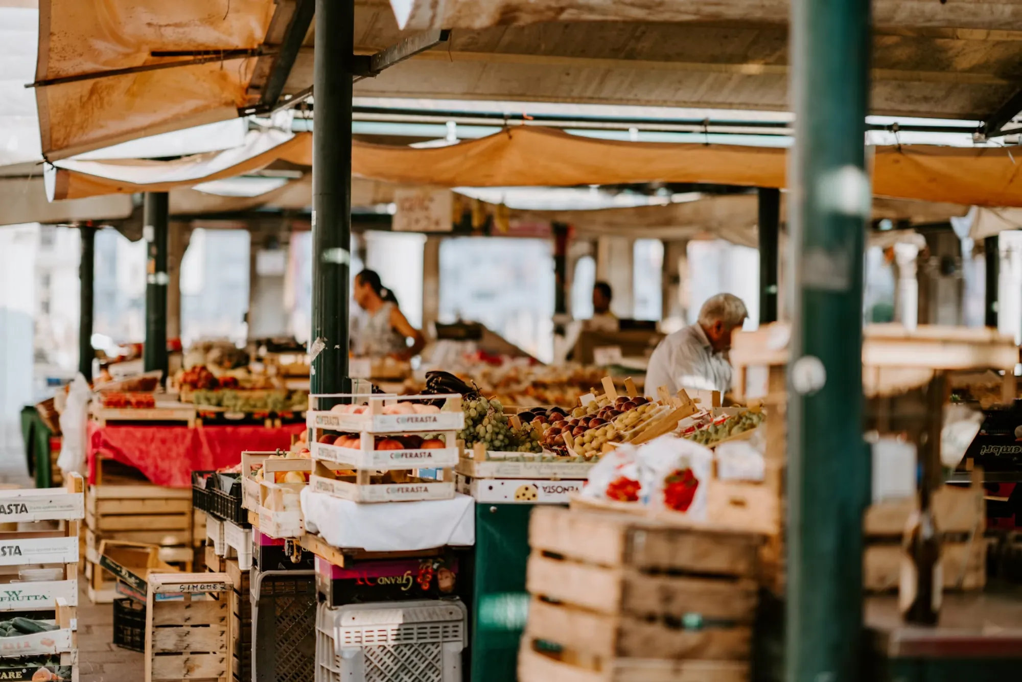 A covered produce market with crates of fruit